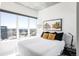 Bright bedroom with large window overlooking the city, neutral decor and comfortable bedding at 891 14Th St # 2816, Denver, CO 80202