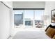 Bright bedroom with a large window view of the city, with neutral decor and comfortable bedding at 891 14Th St # 2816, Denver, CO 80202