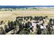 Expansive aerial view showcasing a large property surrounded by trees and fields at 1059 S Elbert St, Elizabeth, CO 80107
