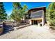 Backyard with lush landscaping, stairs leading to the upper level, and a patio below a screened-in porch at 1059 S Elbert St, Elizabeth, CO 80107