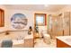 Well-lit bathroom featuring a tub, glass-enclosed shower, and decorative accents at 1059 S Elbert St, Elizabeth, CO 80107
