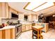 Bright kitchen with modern stainless steel appliances, stone backsplash, and light wood cabinets at 1059 S Elbert St, Elizabeth, CO 80107