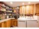 Bright laundry room with side-by-side machines, storage cabinets, countertops and shelves at 1059 S Elbert St, Elizabeth, CO 80107