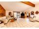 Bright living room with tile flooring, wood trim, and access to the outdoor covered deck at 1059 S Elbert St, Elizabeth, CO 80107