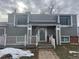 Charming two-story home featuring a cozy front porch, gray siding, and brick accents, creating a welcoming curb appeal at 15716 E Temple Pl, Aurora, CO 80015