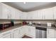 Well-organized kitchen featuring white cabinets and stainless steel dishwasher at 15716 E Temple Pl, Aurora, CO 80015