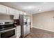 Kitchen with stainless steel refrigerator, breakfast bar and stove at 15716 E Temple Pl, Aurora, CO 80015