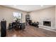 Living room featuring a stone fireplace, a window view, wood floors, and a work desk at 15716 E Temple Pl, Aurora, CO 80015