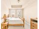 Bright bedroom with wood furniture and two windows at 150 S Madison St # 112, Denver, CO 80209