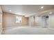 Large finished basement with neutral carpet, a window, and a door leading to an unfinished area at 22455 E Plymouth Cir, Aurora, CO 80016