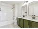 Bathroom featuring dual sinks, green vanity, and a shower at 22455 E Plymouth Cir, Aurora, CO 80016