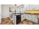 Kitchen featuring dark countertops, white cabinets, updated appliances, and a central island at 22455 E Plymouth Cir, Aurora, CO 80016