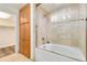 Bright bathroom with a bathtub, glass shower doors, and convenient built-in storage at 1827 N Grant St # 604, Denver, CO 80203