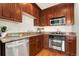 Modern kitchen featuring stainless steel appliances, wooden cabinetry, and granite countertops at 1827 N Grant St # 604, Denver, CO 80203