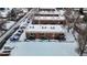 Aerial view of cozy apartments with snowy landscaping and convenient parking at 3663 S Sheridan Blvd # P1, Denver, CO 80235
