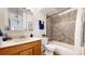 Bathroom features a shower-tub combination, wooden vanity, and coordinated decor at 3663 S Sheridan Blvd # P1, Denver, CO 80235