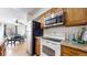 Kitchen featuring stainless steel appliances, wooden cabinets, and an adjacent dining area at 3663 S Sheridan Blvd # P1, Denver, CO 80235