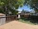 Large backyard with wooden deck, mature trees, and a storage shed fully enclosed by a wooden fence at 16753 E Ithaca Pl, Aurora, CO 80013