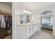 Primary bathroom with double vanity, arched doorway to primary bedroom, and walk-in closet at 6468 S Forest St, Centennial, CO 80121