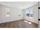Bright bedroom with sleek wood flooring, complemented by natural light streaming through several windows at 5583 Riverbend Ave, Firestone, CO 80504