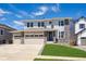 Inviting two-story home featuring stone accents, a three-car garage, and a well-maintained lawn at 5583 Riverbend Ave, Firestone, CO 80504