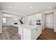 Bright kitchen features an island with quartz countertops, white cabinets and stainless steel appliances at 5583 Riverbend Ave, Firestone, CO 80504