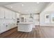 Open kitchen featuring white cabinets, stainless steel appliances, and a large island at 5583 Riverbend Ave, Firestone, CO 80504