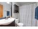 Functional bathroom with a vanity, toilet, mirror, and a shower with a patterned curtain at 1801 Aspen St, Fort Lupton, CO 80621