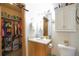 Hall bathroom featuring toilet, vanity, medicine cabinet and storage, with a walk-in closet at 1801 Aspen St, Fort Lupton, CO 80621