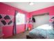 Colorful bedroom featuring pink walls, geometric accents, and a closet space at 1801 Aspen St, Fort Lupton, CO 80621