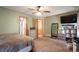 Large bedroom with a ceiling fan, dresser and views into the attached bathroom and closet at 1801 Aspen St, Fort Lupton, CO 80621
