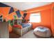 Brightly painted bedroom with a sports theme, a built-in headboard and a cozy beanbag chair at 1801 Aspen St, Fort Lupton, CO 80621