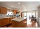 Bright kitchen featuring wood cabinets, an island, and an adjacent dining area at 1801 Aspen St, Fort Lupton, CO 80621
