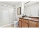 Bright bathroom featuring a glass enclosed shower, framed art, and vanity with cabinet storage at 5444 Zephyr St # 203, Arvada, CO 80002
