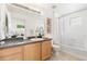 Bright bathroom featuring a vanity, large mirror, decorative wall art, and a shower-tub combo at 5444 Zephyr St # 203, Arvada, CO 80002