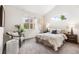 Comfortable bedroom featuring a tufted headboard, soft throw blanket, and ample natural light from the windows at 5444 Zephyr St # 203, Arvada, CO 80002