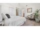 Bright bedroom with a sliding door closet, comfortable chair, and view into ensuite bath at 5444 Zephyr St # 203, Arvada, CO 80002
