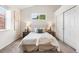 Comfortable bedroom featuring a tufted headboard, soft throw blanket, and a double door closet at 5444 Zephyr St # 203, Arvada, CO 80002