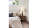 Bedroom showcasing a tufted headboard, a decorative lamp, and a bedside table with drawers at 5444 Zephyr St # 203, Arvada, CO 80002