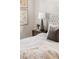 Bedroom showcasing a tufted headboard, decorative floral art, and a bedside table with drawers at 5444 Zephyr St # 203, Arvada, CO 80002
