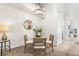 Bright dining area features a glass table, modern chandelier, and a stylish round mirror at 5444 Zephyr St # 203, Arvada, CO 80002