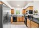 Well-lit kitchen showcasing stainless steel refrigerator and plentiful wood cabinetry at 5444 Zephyr St # 203, Arvada, CO 80002