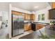 Spacious kitchen features a stainless steel refrigerator and view into the living room at 5444 Zephyr St # 203, Arvada, CO 80002