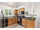 Bright kitchen featuring wood cabinets, stainless steel refrigerator, and view to the living room at 5444 Zephyr St # 203, Arvada, CO 80002