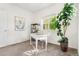 Bright office space featuring a white desk, large houseplant, and shelving unit at 5444 Zephyr St # 203, Arvada, CO 80002