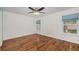 Bright bedroom with hardwood floors and natural light from two windows with blue shades at 7834 S Windermere Cir, Littleton, CO 80120