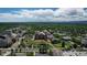 Aerial view of an area with tall buildings, green trees, ponds, landscaping, and distant mountains at 2500 S York St # 116, Denver, CO 80210