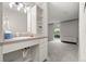 Bright bathroom featuring an open vanity, modern lighting fixtures, and storage shelves next to the sink at 2500 S York St # 116, Denver, CO 80210