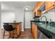 Well-lit kitchen with wooden cabinetry, stainless steel appliances, and an adjacent breakfast bar with two chairs at 2500 S York St # 116, Denver, CO 80210