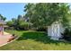 Spacious backyard with green lawn, mature trees, and a storage shed at 2920 S York St, Denver, CO 80210